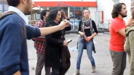 Antonucci (de polera roja) aparece en el video separando a manifestantes de la mujer agredida.