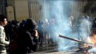 Encapuchado prepara bomba molotov saliendo de Casa Central