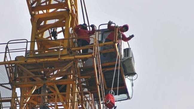 Trabajadores protestan sobre una grúa en Concepción