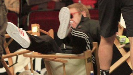   Elton John quedó en ridículo al caer de una silla durante un partido de tenis 