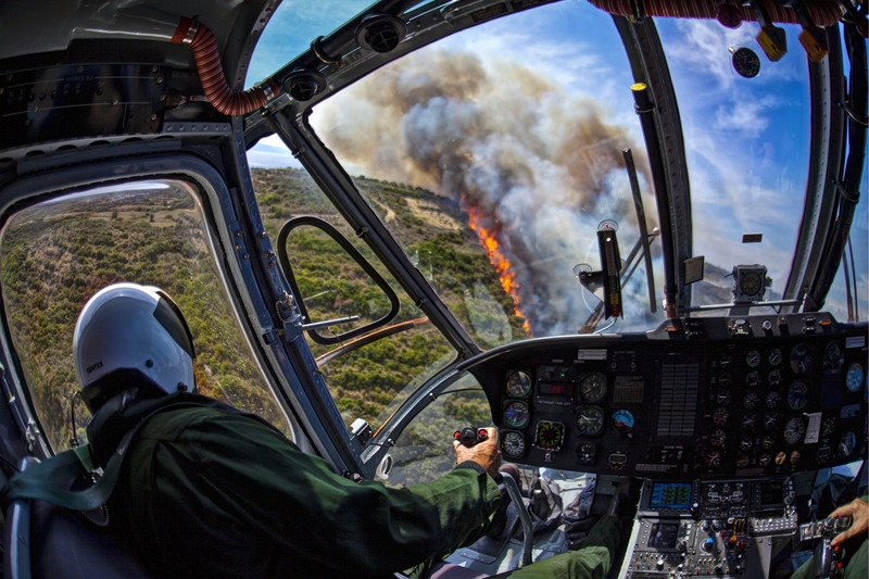 View from an aerial firefighting helicopter cockpit above smoke