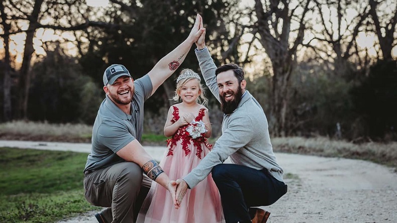 Emotiva foto de niña con sus dos papás se volvió viral