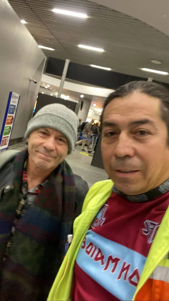 bruce dickinson en el aeropuerto de santiago junto a fanatico